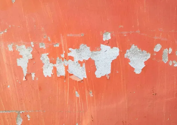 Peeling orange surface coating on a wall